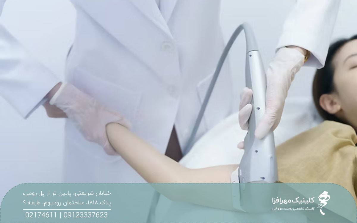 دختری که روی تخت کلینیک خوابیده است و پزشک دست او را بالا گرفته است و بازوی او را هایفو می کند